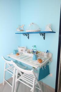 a table with two chairs and a blue wall at Le Nereidi BeB in Margherita di Savoia