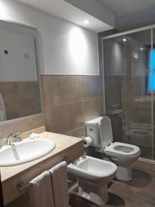 bagno con lavandino, servizi igienici e specchio di Hotel Las Cascadas a La Cumbrecita