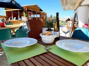 a wooden table with two plates and wine glasses on it at CHALET DES ALPES in Gressan