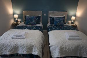 two beds sitting next to each other in a room at The Evergreen Inn in Banbury