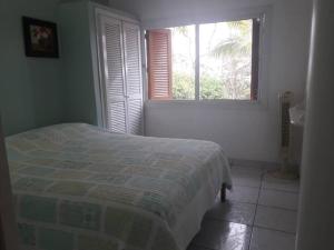 a white bedroom with a bed and a window at HERMOSA CASA PARA 13 PERSONAS EN CASABLANCA, ECUADOR in Same