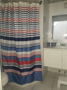 uma casa de banho com uma cortina de duche listrada e um lavatório em HERMOSA CASA PARA 13 PERSONAS EN CASABLANCA, ECUADOR em Same