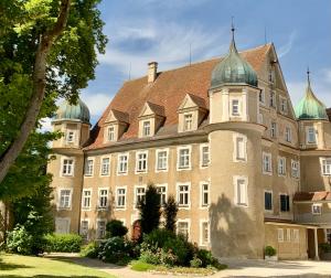 un gran edificio con techo con cúpulas verdes en Schloß Hürbel Rosengarten - Suite, en Gutenzell-Hürbel