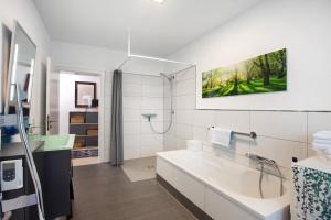 a white bathroom with a sink and a shower at Stadt Land Fluss Plus in Arnsberg