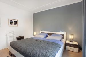 a white bedroom with a large bed and two lamps at Stadt Land Fluss Plus in Arnsberg