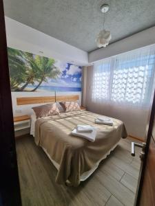 a bedroom with a large bed with a painting on the wall at View Beach in Villa Gesell