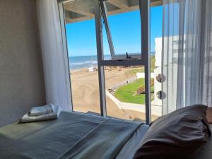 a bedroom with a bed and a view of the beach at View Beach in Villa Gesell