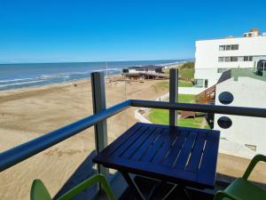 a blue bench on a balcony overlooking the beach at View Beach in Villa Gesell