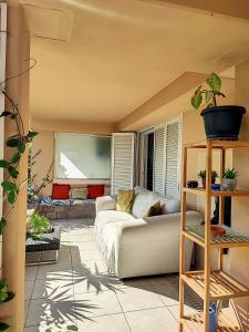 a living room with a couch and a table at Superbe appartement avec Jardin in Villeneuve-Loubet