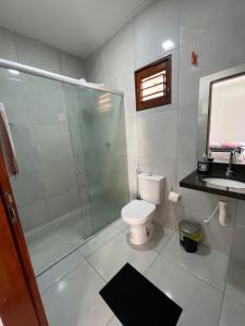 uma casa de banho com um WC, um chuveiro e um lavatório. em Pousada MKC em São Gonçalo do Amarante