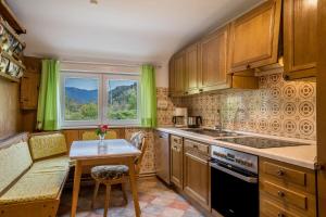 cocina con armarios de madera, mesa y ventana en Lehmann mit Blick aufs Schloss, en Gutach