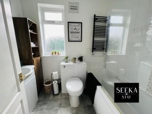 a bathroom with a toilet and a tub and a sink at Greenwood in Coventry