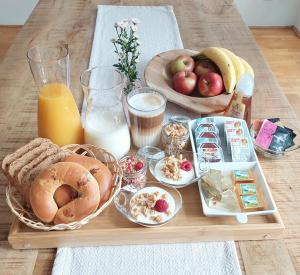 einen Tisch mit einem Tablett mit Frühstückszutaten und Getränken in der Unterkunft Vienna Charm Apartment in Wien