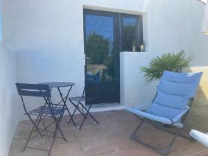 a patio with two chairs and a table in front of a door at Le Cube in Marans +1 photo