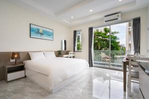 a white bedroom with a bed and a balcony at F-APARTMENT in Ho Chi Minh City +55 photos