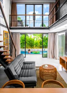 a living room with a couch and a table at KAMMARA LOFT - Bali Invest Club in Canggu