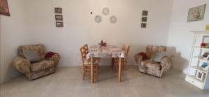 a dining room with a table and two chairs at A day at Dee's in Birżebbuġa