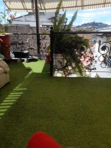 a patio with grass and plants on a balcony at Hostal Atlantis in Quito