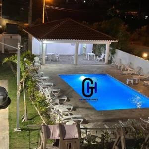 einen Pool mit Stühlen und einen Pavillon neben einem Pool in der Unterkunft Apartamento Con piscina cerca de la playa in La Romana