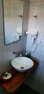 a bathroom with a white sink and a mirror at Pousada Sertão in Alto Paraíso de Goiás