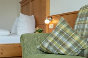 uma almofada sentada num sofá num quarto de hotel em Appartement Predigstuhlblick mit Indoorpool und Sauna em Bad Goisern