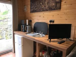 a kitchen with a counter with a television on it at Ogdenclough fisherie log cabin in Rochdale