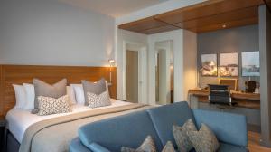 una camera d'albergo con un letto e un divano blu di Clayton Hotel London Wall a Londra