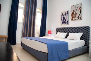 a bedroom with a large bed with blue curtains at La Grande Suite de Tozeur in Tozeur