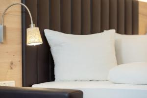 a lamp next to a bed with white pillows at Appartement Mühlkogel in Bad Goisern