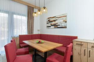 una sala da pranzo con sedie rosse e tavolo in legno di Appartement Mühlkogelblick mit Indoorpool und Sauna a Bad Goisern