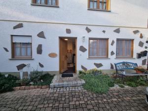 une maison blanche avec une porte et un banc devant elle dans l'établissement Ferienwohnung Kuckuck, à Ohlsbach