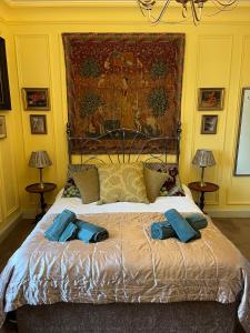 a bedroom with a large bed with two blue pillows at Chez Vivienne in Ilkley