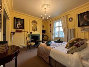 a bedroom with a bed and a desk and a fireplace at Chez Vivienne in Ilkley