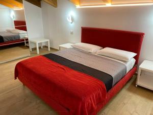 1 dormitorio con 1 cama grande con manta roja en Il Ciliegio Relax & Wellness, en Druento
