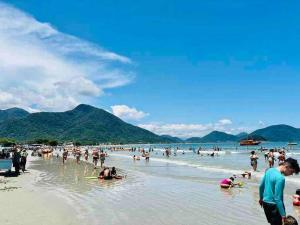 eine große Gruppe von Menschen am Strand in der Unterkunft Meu Lar Meu Mar 1 in Ubatuba