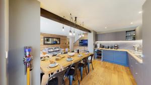 a dining room and kitchen with a long table and chairs at Nouveau ! Chalet pied des pistes in Champagny-en-Vanoise