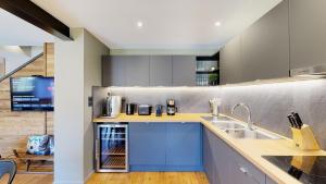 a kitchen with blue cabinets and a sink at Nouveau ! Chalet pied des pistes in Champagny-en-Vanoise