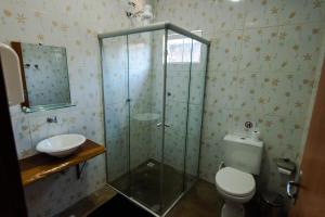 uma casa de banho com um chuveiro, um WC e um lavatório. em Pousada Sertão em Alto Paraíso de Goiás
