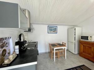 a kitchen with a table and a refrigerator at Charmante maison / Proche du lac de Casteljaloux in Casteljaloux