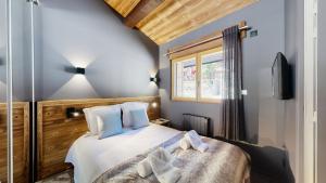 a bedroom with a bed and a window at Nouveau ! Chalet pied des pistes in Champagny-en-Vanoise
