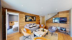 a living room with a couch and a tv at Nouveau ! Chalet pied des pistes in Champagny-en-Vanoise