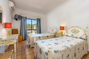 a bedroom with two beds and a balcony at Hotel Sol e Serra in Castelo de Vide