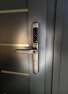 una maniglia della porta con un cellulare sopra di MONARC Boutique ApartHotel - SELF CHECK-IN a Iaşi