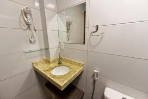 a bathroom with a sink and a phone at Hotel Mais1 in Campina Grande