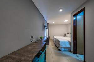a hotel room with a bed and a mirror at Hotel Mais1 in Campina Grande