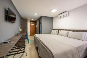 a hotel room with a large bed and a television at Hotel Mais1 in Campina Grande
