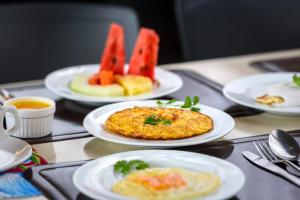 a tray with plates of food on a table at Hotel Mais1 in Campina Grande