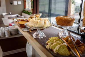 a buffet with several different types of bread and cakes at Hotel Mais1 in Campina Grande