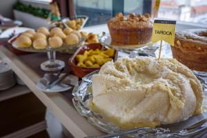 a table with a cake and other desserts on it at Hotel Mais1 in Campina Grande