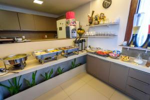 a kitchen with several pans of food on a counter at Hotel Mais1 in Campina Grande